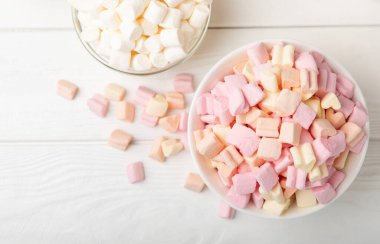 Beyaz desenli cam bir kasede marshmallow. Rustik stil. Yakından büyük şekerler, partiler için abur cuburlar, kahve ve kakao. Kış yiyeceği konsepti. Kopya için yer..