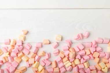 Beyaz dokuda gevşek meyve şekerlemeleri. Atıştırmalık tatlı ve atıştırmalıklar. Yakın plan çiğneme..