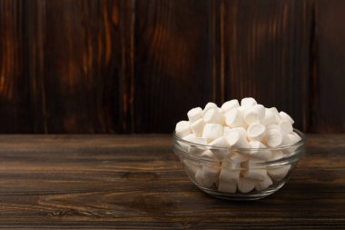 Kahverengi desenli ahşap üzerinde lokum. Beyaz lokum. Atıştırmalık tatlı ve atıştırmalıklar. Şekerleri yakından çiğniyor. Uzayı kopyala Metin için yer.