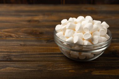 Kahverengi desenli ahşap üzerinde lokum. Beyaz lokum. Atıştırmalık tatlı ve atıştırmalıklar. Şekerleri yakından çiğniyor. Uzayı kopyala Metin için yer.