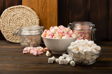 Bir sürü farklı marşmelov kaselerde ve kahverengi desenli ahşap kavanozlarda. Beyaz ve meyveli lokum. Atıştırmalık tatlı ve atıştırmalıklar. Şekerleri yakından çiğniyor. Uzayı kopyala Metin için yer.