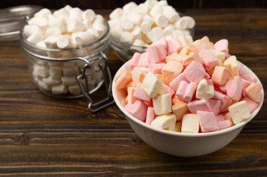 Bir sürü farklı marşmelov kaselerde ve kahverengi desenli ahşap kavanozlarda. Beyaz ve meyveli lokum. Atıştırmalık tatlı ve atıştırmalıklar. Şekerleri yakından çiğniyor. Uzayı kopyala Metin için yer.