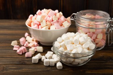 Bir sürü farklı marşmelov kaselerde ve kahverengi desenli ahşap kavanozlarda. Beyaz ve meyveli lokum. Atıştırmalık tatlı ve atıştırmalıklar. Şekerleri yakından çiğniyor. Uzayı kopyala Metin için yer.