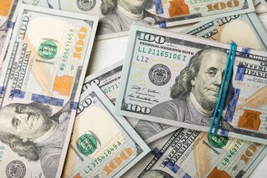 Para, beyaz ahşap arka planda 100 dolarlık banknotlar. Para masanın üzerine saçıldı. Finans ve ekonomi kavramları. Para birikimi. Para tasarrufu. Yatırım..
