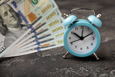 Para banknotlarındaki mavi alarm saati dolar, iş planlama ve finans kavramları. Zaman paradır. Finans ve ekonomi kavramları. Para biriktirme konsepti. Para biriktiriyorum. Yatırımlar. Boşluğu kopyala.