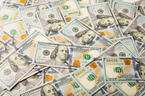 Money, US hundred dollar bills background on white wooden background. Money is scattered on the table. Finance and economics concepts.Money accumulation concept.Currency saving.Investment.Copy space.