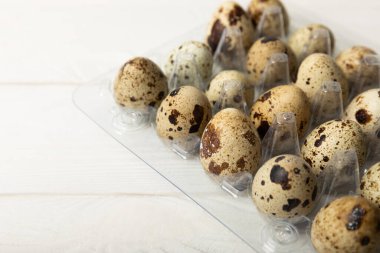 Beyaz arka planda plastik bir pakette bıldırcın yumurtası. Doğal ürünler. Mesaj için yer. taze yumurta