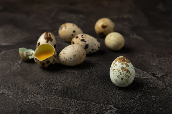 黒のテクスチャの背景に卵をウズラ 全体と壊れたウズラの卵 天然物 テキスト用の場所 新鮮なウズラの卵 — ストック写真