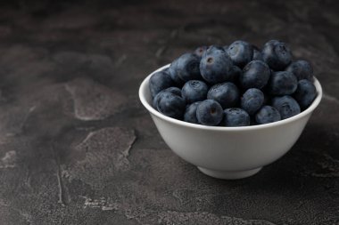 Siyah desenli arka planda seramik bir kasede yaban mersini. Olgun ve taze yaban mersini. Vitaminler. Sağlıklı yiyecekler. Sulu böğürtlen. Boşluğu kopyala. Mesaj için yer