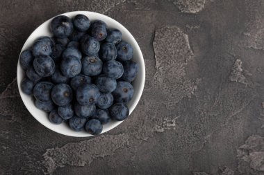 Siyah desenli arka planda seramik bir kasede yaban mersini. Olgun ve taze yaban mersini. Vitaminler. Sağlıklı yiyecekler. Sulu böğürtlen. Boşluğu kopyala. Mesaj için yer