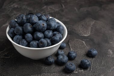 Siyah desenli arka planda seramik bir kasede yaban mersini. Olgun ve taze yaban mersini. Vitaminler. Sağlıklı yiyecekler. Sulu böğürtlen. Boşluğu kopyala. Mesaj için yer