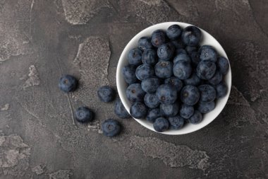 Siyah desenli arka planda seramik bir kasede yaban mersini. Olgun ve taze yaban mersini. Vitaminler. Sağlıklı yiyecekler. Sulu böğürtlen. Boşluğu kopyala. Mesaj için yer