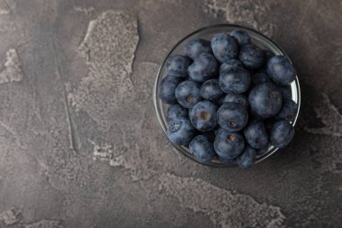 Siyah desenli arka planda seramik bir kasede yaban mersini. Olgun ve taze yaban mersini. Vitaminler. Sağlıklı yiyecekler. Sulu böğürtlen. Boşluğu kopyala. Mesaj için yer