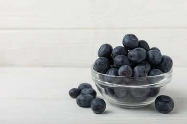 Beyaz desenli arka planda yaban mersini kasesi. Olgun ve taze yaban mersini. Vitaminler. Sağlıklı yemek. Meyve suyu. Uzayı kopyala Metin için yer