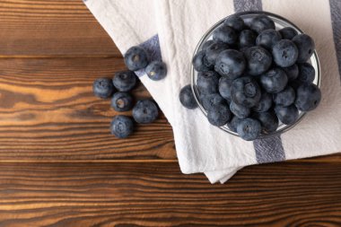 Kahverengi desenli arka planda yaban mersini kasesi. Olgun ve taze yaban mersini. Vitaminler. Sağlıklı yemek. Meyve suyu. Uzayı kopyala Metin için yer