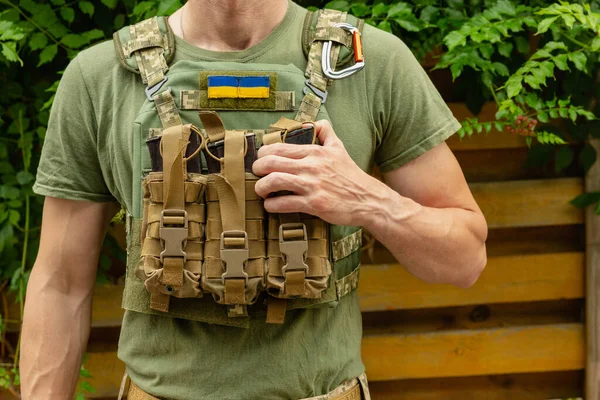 木と緑の背景にカモフラージュ戦術的な制服と軍用ボディアーマーを持つ兵士 戦闘用のバットを持つボディアーマー ウクライナ軍 軍事的概念 戦争なし メディカル トーナメント — ストック写真