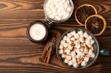 Kahverengi dokuma masasında kış içecekleri için marşmelovlar ve marşmelovlar. Kış içeceği. Marshmallow ve baharatlı sıcak çikolata..