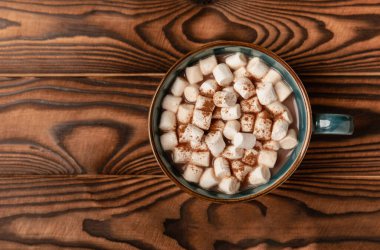 Kahverengi dokuma masasında kış içecekleri için marşmelovlar ve marşmelovlar. Kış içeceği. Marshmallow ve baharatlı sıcak çikolata..