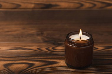 Kahverengi desenli kahverengi cam kavanozda yanan mum. Kış evi dekorasyonu. Soya ekolojik mumu. Ev ve iç dekorasyon. Ders için yer..