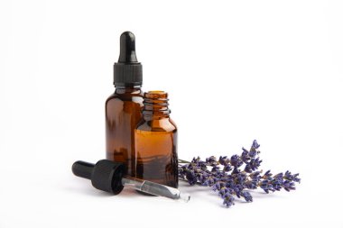 Cam şişede pipetli lavanta yağı. Beyaz arka planda izole edilmiş kokulu yağ ve lavanta çiçekleri olan şişe. Kopya alanlı lavanta yağı modeli. Serum.