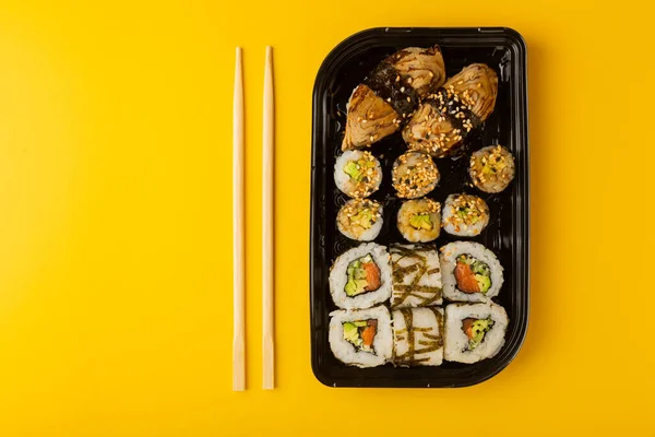 Pyszne Bułki Sushi Jednorazowych Pudełkach Żółtym Tle Koncepcja Dostarczania Żywności — Zdjęcie stockowe