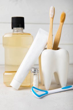 Ağız temizliği ürünleri ve beyaz ahşap arka planda diş modelleri. Diş fırçası, diş macunu ve ağız gargarası beyaz arka planda. Diş sağlığı konsepti. Ağız bakımı konsepti.