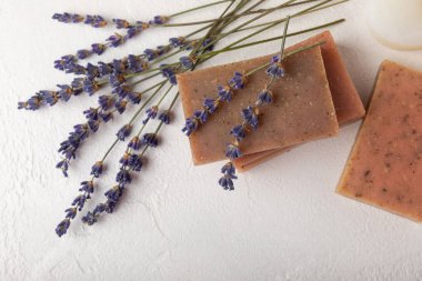 Beyaz çimento üzerine lavanta çiçekli doğal lavanta sabunu. El yapımı sabun. Temel yağlı kozmetik ürünü. Düz yatıyordu.