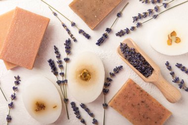 Beyaz çimento üzerine lavanta çiçekli doğal lavanta sabunu. El yapımı sabun. Temel yağlı kozmetik ürünü. Düz yatıyordu.