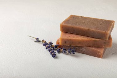 Beyaz çimento üzerine lavanta çiçekli doğal lavanta sabunu. El yapımı sabun. Temel yağlı kozmetik ürünü. Düz yatıyordu.