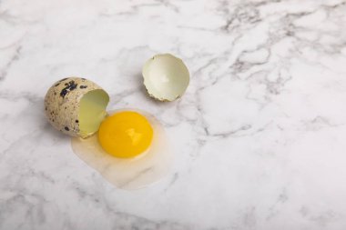 Yüzeyde kırık bıldırcın yumurtası. Beyaz mermer arka planda bıldırcın yumurtaları. Doğal ürünler. Mesaj için yer. taze yumurta