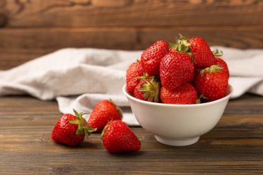 Kahverengi desenli bir kasede taze olgun çilekler. Vejetaryen organik böğürtlen. Sağlıklı yiyecek.