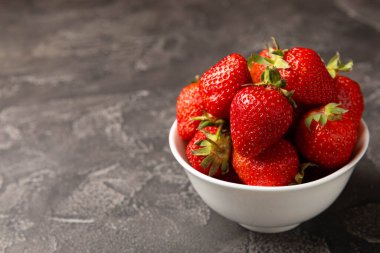 Siyah desenli bir tabakta taze olgun çilekler. Vejetaryen organik böğürtlen. Sağlıklı yiyecek. Vitamin.