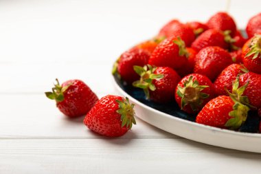 Beyaz ahşap bir arka planda taze olgun çilekler. Vejetaryen organik böğürtlen. Sağlıklı yiyecek. Vitamin.