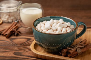 Kahverengi dokuma masasında kış içecekleri için marşmelovlar ve marşmelovlar. Kış içeceği. Marshmallow ve baharatlı sıcak çikolata..