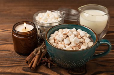 Kahverengi dokuma masasında kış içecekleri için marşmelovlar ve marşmelovlar. Kış içeceği. Marshmallow ve baharatlı sıcak çikolata..