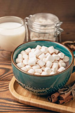 Kahverengi dokuma masasında kış içecekleri için marşmelovlar ve marşmelovlar. Kış içeceği. Marshmallow ve baharatlı sıcak çikolata..