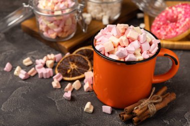 Doku arka planında kakao içmek. Küçük marşmelov ve baharatlı sıcak çikolata. Kış içeceği konsepti. Kopya için yer var. Metin için boşluk