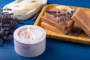 Mavi ahşap desenli beton bir tencerede sıcak mum. Lavanta aromalı mum. Rahatla. Kışın ev dekorasyonu. Soya ekolojik mumu. Ev ve iç dekorasyon. Metin için yer.