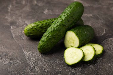 Siyah mermer zemine karşı taze organik salatalıklar. Salatalık dilimleri. Salata malzemesi. Taze sebzeler. Vejetaryen yemeği. Sağlıklı yiyecekler. Taze organik sebzeler.