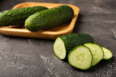 Siyah mermer zemine karşı taze organik salatalıklar. Salatalık dilimleri. Salata malzemesi. Taze sebzeler. Vejetaryen yemeği. Sağlıklı yiyecekler. Taze organik sebzeler.