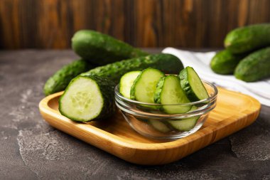 Siyah mermer zemine karşı taze organik salatalıklar. Salatalık dilimleri. Salata malzemesi. Taze sebzeler. Vejetaryen yemeği. Sağlıklı yiyecekler. Taze organik sebzeler.