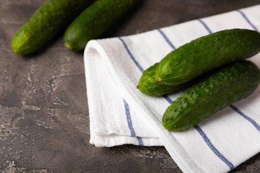 Beyaz siyah dokuda taze salatalıklar. Vejetaryen organik sebzeler. Salata için. Sağlıklı yiyecek. Boşluğu kopyala. Metin için yer