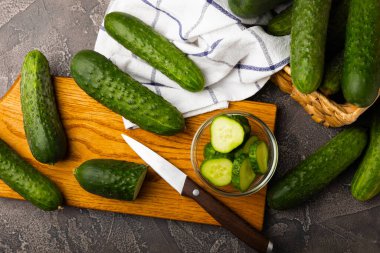 Siyah mermer zemine karşı taze organik salatalıklar. Salatalık dilimleri. Salata malzemesi. Taze sebzeler. Vejetaryen yemeği. Sağlıklı yiyecekler. Taze organik sebzeler.