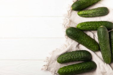 Beyaz ahşap üzerinde taze salatalıklar. Vejetaryen organik sebzeler. Salata için. Sağlıklı yiyecek. Boşluğu kopyala. Metin için yer