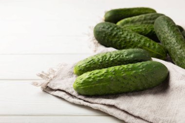 Beyaz ahşap üzerinde taze salatalıklar. Vejetaryen organik sebzeler. Salata için. Sağlıklı yiyecek. Boşluğu kopyala. Metin için yer