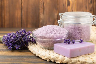 Lavanta kaplıcası. Deniz tuzu, lavanta çiçekleri ve el yapımı sabun. Kahverengi desenli lavanta çiçekli doğal bitkisel kozmetik. Spa ve rahatlama konsepti. Güzellik tedavileri..