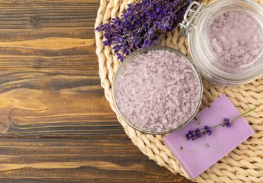 Lavanta kaplıcası. Deniz tuzu, lavanta çiçekleri ve el yapımı sabun. Kahverengi desenli lavanta çiçekli doğal bitkisel kozmetik. Spa ve rahatlama konsepti. Güzellik tedavileri..