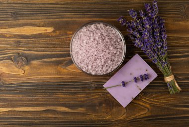 Lavanta kaplıcası. Deniz tuzu, lavanta çiçekleri ve el yapımı sabun. Kahverengi desenli lavanta çiçekli doğal bitkisel kozmetik. Spa ve rahatlama konsepti. Güzellik tedavileri..