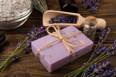 Lavanta kaplıcası. Deniz tuzu, lavanta çiçekleri ve el yapımı sabun. Kahverengi desenli lavanta çiçekli doğal bitkisel kozmetik. Spa ve rahatlama konsepti. Güzellik tedavileri..