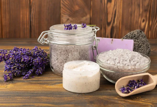 Lavender spa. Sea salt, body scrub, lavender flowers and handmade soap. Natural herbal cosmetics with lavender flowers on brown texture wood.Spa and relaxation concept.Beauty treatments.Copy space.